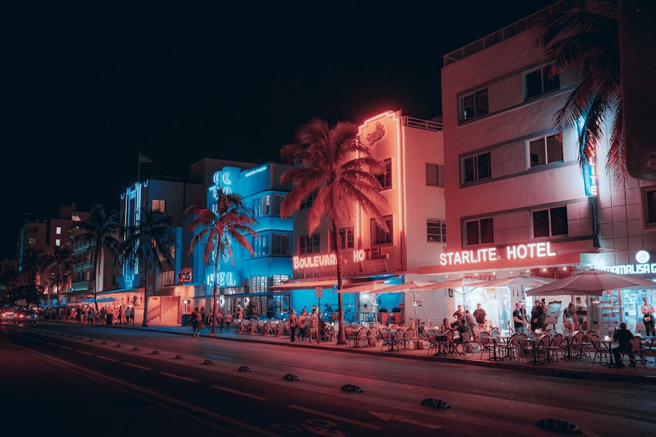 Colorful Art Deco hotels and lively street scene on Ocean Drive at night in Miami Beach.