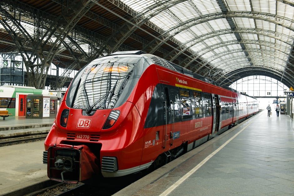 A modern red train at Leipzig Central Station, showcasing railway architecture.