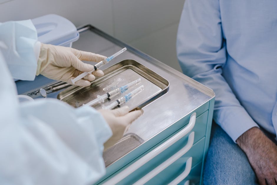 Medical professional preparing syringes for vaccination in a clinical setting.