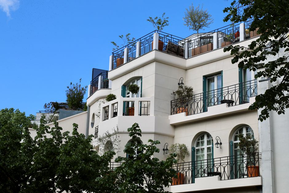 Charming Parisian apartment building with balconies set against a clear blue sky.