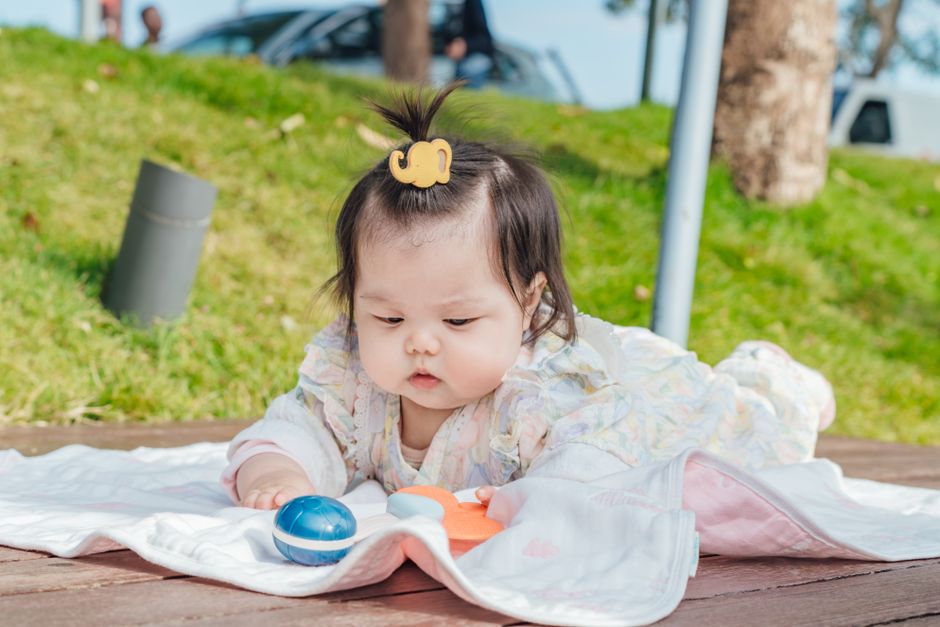 Charming toddler engaged with toys on a sunny day outside, enjoying playful fun.