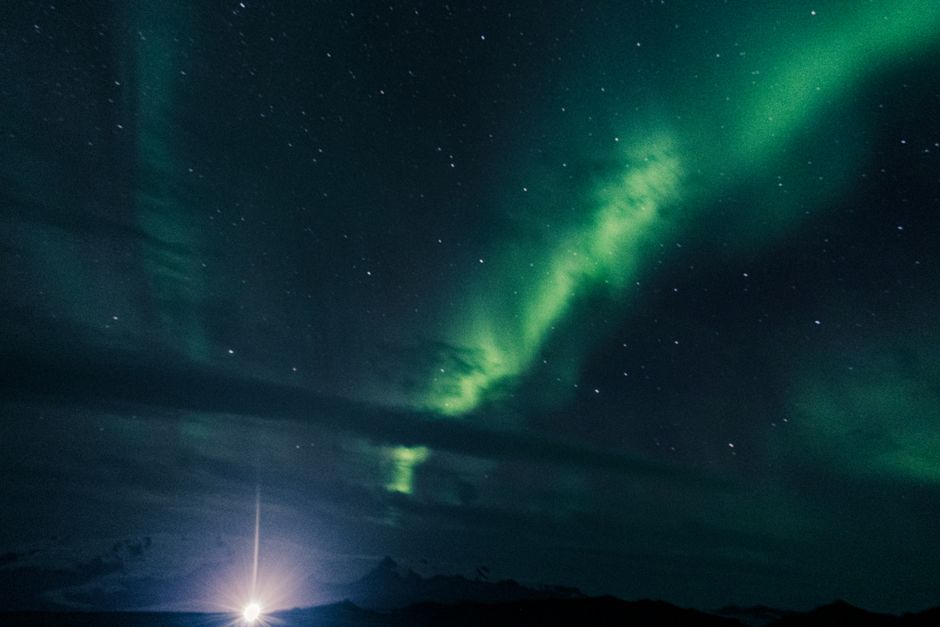 A stunning view of the Northern Lights with stars illuminating the dark night sky, creating a mesmerizing natural phenomenon.