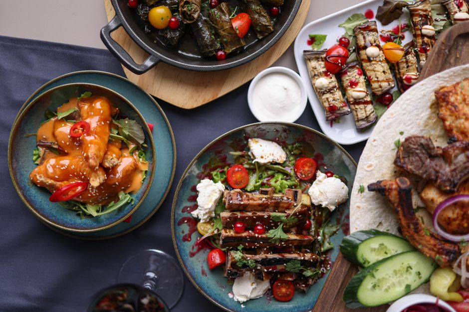 A vibrant collection of gourmet dishes featuring meat, vegetables, and sauces, ideal for a culinary showcase.