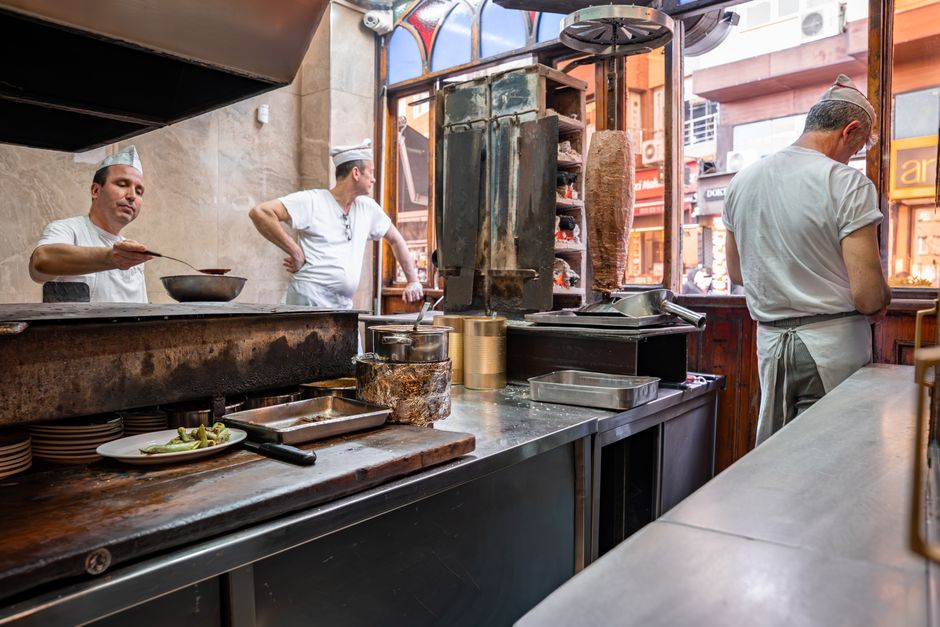 A bustling scene inside a Turkish döner shop kitchen in Bursa, Türkiye, showcasing culinary preparations.