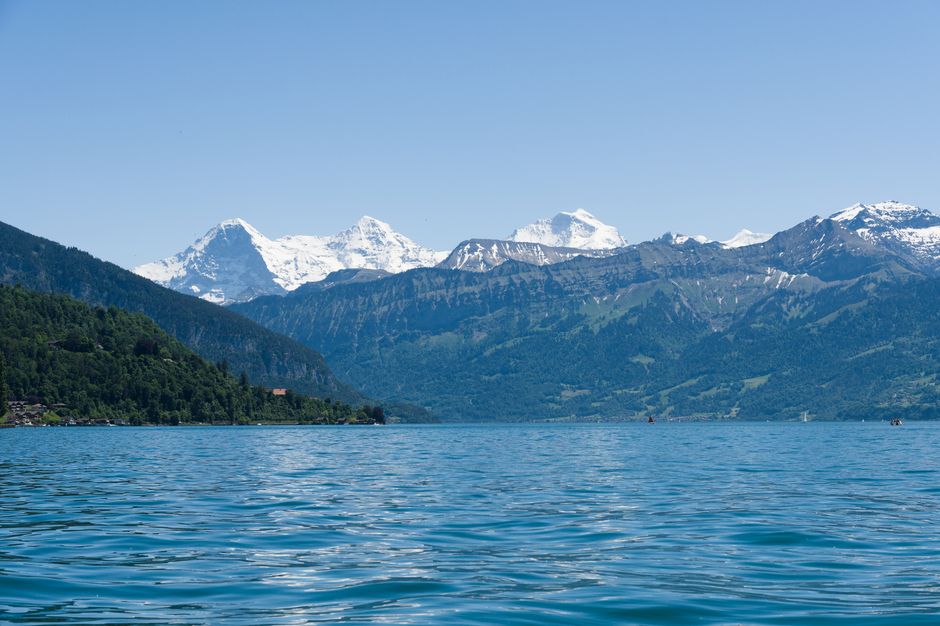 Majestic view of Lake Thun framed by the Swiss Alps under a clear blue sky in Interlaken.