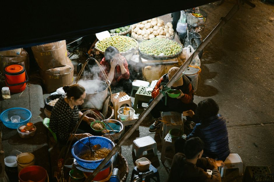 High angle view of people enjoying food at a vibrant night market.