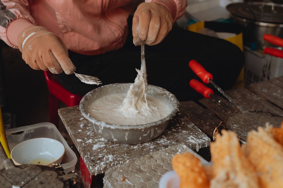 A vendor prepares traditional street food in Bình Thuận, Vietnam with special tools.
