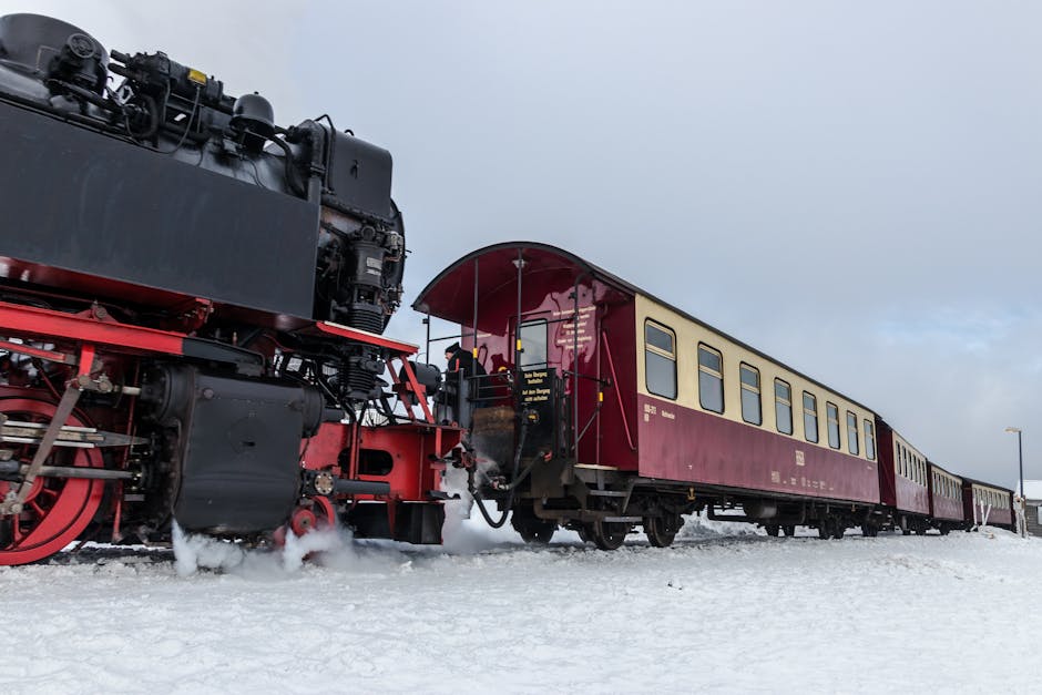 A historic steam locomotive captured against a snowy winter background, showcasing vintage travel charm.